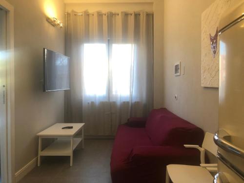 a living room with a red couch and a window at Residenza Segrate Centro Novegro in Segrate