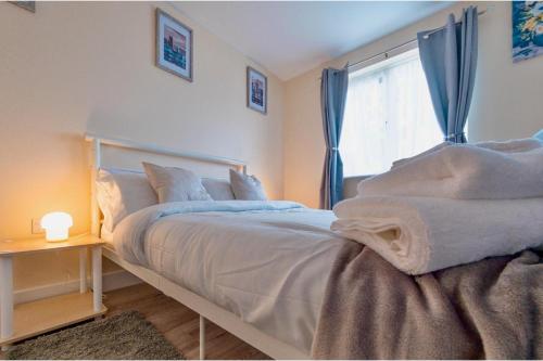 ein Schlafzimmer mit einem großen Bett mit Fenster in der Unterkunft Cosy Home-Sleeps 5- Private Garden- Free Parking in Corby