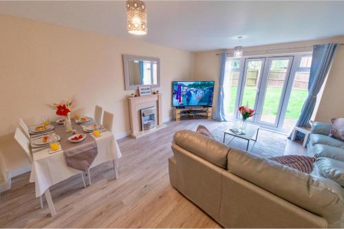 a living room with a couch and a tv at Cosy Home-Sleeps 5- Private Garden- Free Parking in Corby