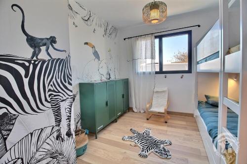 une chambre pour enfants avec une fresque murale de zébr et de dinosaure dans l'établissement Echappées Belles, à Trévou-Tréguignec