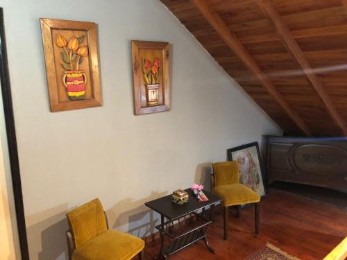 a living room with a table and chairs and a painting at La Posada Encantada in Mar del Plata