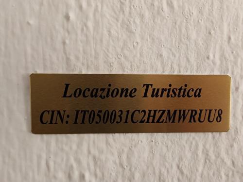 a sign on a wall with the name of a building at Valle delle fonti in Asciano Pisano
