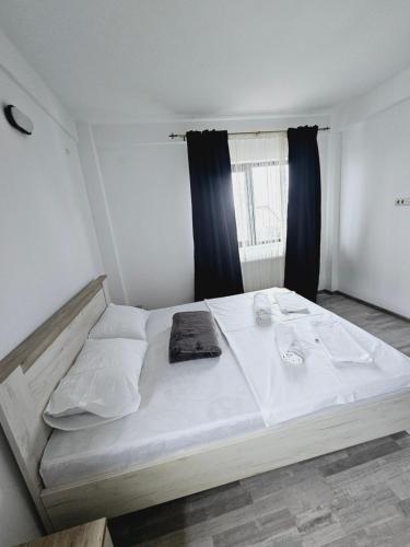 a large white bed in a room with a window at Comapart2 in Bacău
