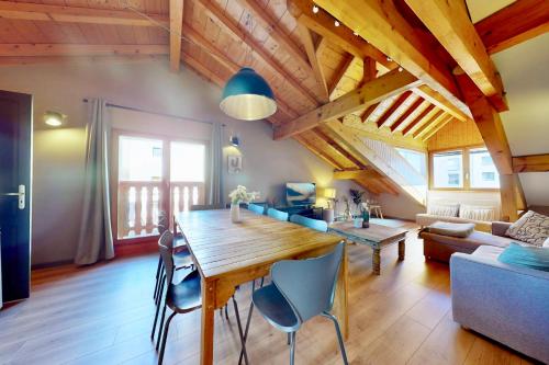 - une salle à manger et un salon avec une table et des chaises en bois dans l'établissement L'Appart 48, à Annecy