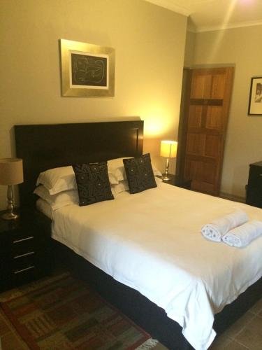 a bedroom with a large white bed with two pillows at The Gateway Inn in Louis Trichardt