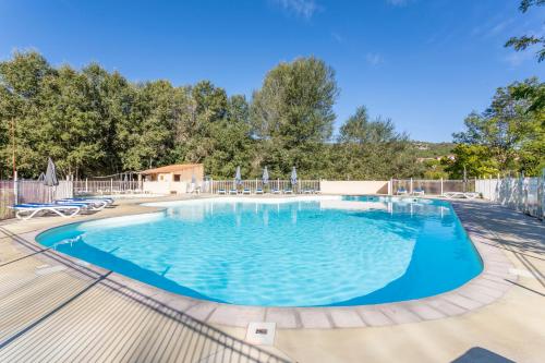 a large swimming pool with blue water at Camping Bel Air Village Les Prés du Verdon in Quinson