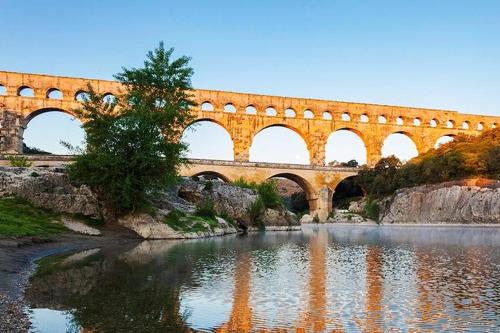 a bridge with many arches over a river at Chambre hôtes jacuzzi climatiseur provence in Tulette