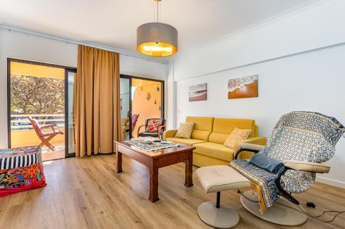 a living room with a couch and a table at 2 Bed-Sleeps 4-Vilamoura Beach-Pool-Spa-Balcony in Quarteira