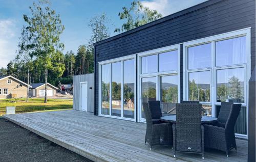a patio with a table and chairs on a deck at Gorgeous Home In Hurdal With Lake View in Hurdal