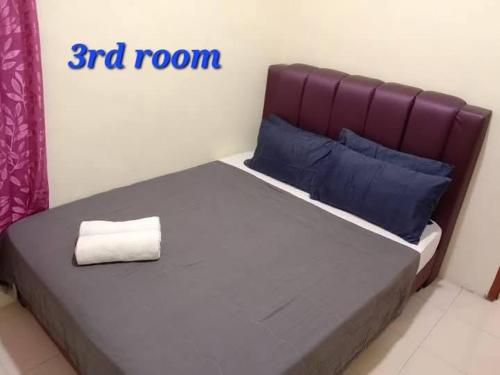 a bedroom with a bed with a room sign at ARUWDA Homestay in Ipoh