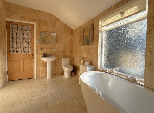 a bathroom with a tub and a toilet and a sink at 45 Eskin Street in Keswick