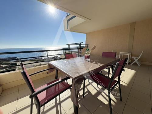 une table et des chaises sur un balcon avec l'océan dans l'établissement appartement 1 chambre avec terrasse vue mer dans residence avec piscine, à Sète