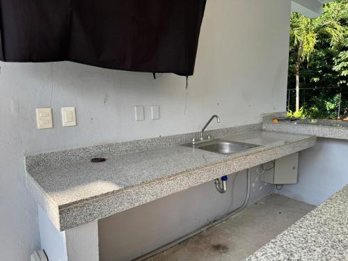 a kitchen counter with a sink and a window at Casa Puerto Paraíso in Puerto Morelos