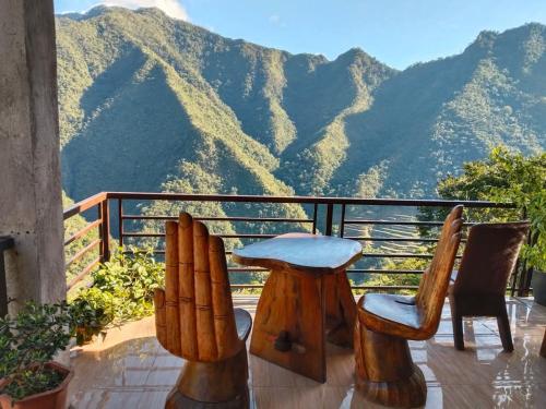 a balcony with two chairs and a view of mountains at Batad Pension and Restaurant in Banaue
