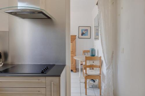 Il comprend une cuisine équipée d'une cuisinière. four supérieur à côté d'une table dans l'établissement Villa Anaite Vue mer et montagne, piscine privée, à Antibes