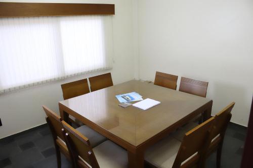 a conference room with a wooden table and chairs at ARQ Inn Hotel in Ribeirão Preto