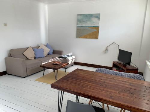 a living room with a couch and a table at Charming 2-Bedroom Maisonette in Leigh-on-Sea