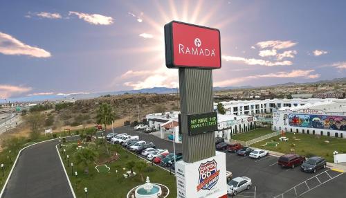 a sign on a pole in front of a parking lot at Ramada by Wyndham Kingman in Kingman