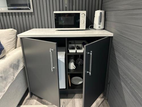 a desk with a microwave and a computer on it at Luxury and Style - The Garden Room in Winslow