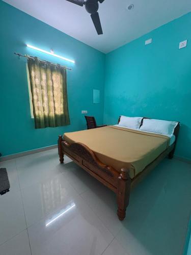 a bedroom with a bed in a blue room at Sri Arunachala Homestay in Tiruvannāmalai