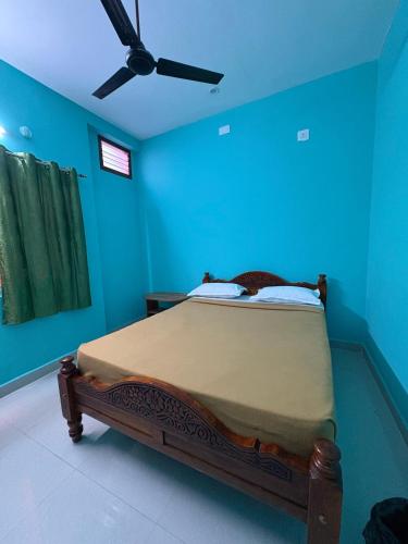 a blue bedroom with a bed with a ceiling fan at Sri Arunachala Homestay in Tiruvannāmalai
