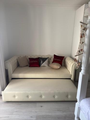 a white couch with pillows on it in a room at Suite Elisir Egitto Domina Coral Bay Resort in Sharm El Sheikh