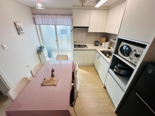 a small kitchen with a pink table in a room at Comfort stay & beyond in Gyeongju