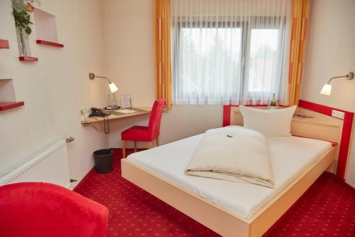 a small room with a bed and a desk at Flair Hotel Landgasthof Roger in Löwenstein