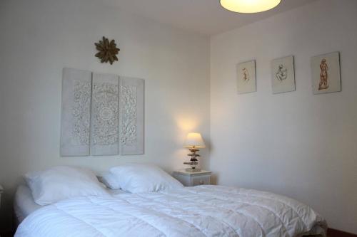 - une chambre dotée d'un lit avec des draps blancs et des photos murales dans l'établissement Appt 3 pièces ILE DE RE - IDR400-010, à Saint-Martin-de-Ré