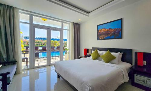 a bedroom with a large bed and a large window at Riverside White House Boutique Hotel in Hoi An