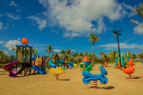 a playground with a bunch of playground equipment in the sand at Sunsol Ecoland in Pedro Gonzalez