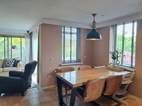 a dining room with a table and chairs at Charmante woning omheinde tuin, dichtbij strandje VP023 in Herkingen