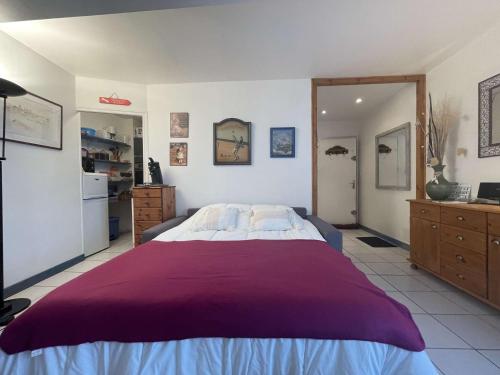 une chambre avec un grand lit avec une couverture violette dans l'établissement Studio - ILE DE RE - IDR400-015, à Saint-Martin-de-Ré