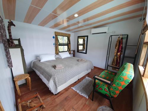 a bedroom with a bed and a chair at Kayube Estate Bungalows in Livingstone