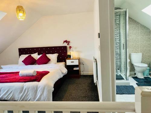 Un dormitorio con una cama con almohadas rojas. en 1 minute walk to Liverpool Stadium Free Private Parking, Anfield Liverpool Entire House, en Liverpool
