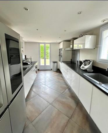 Il comprend une grande cuisine avec des placards blancs et du carrelage. dans l'établissement Single-family home in Mandelieu, à Mandelieu-la-Napoule