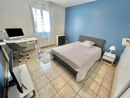 une chambre avec un lit et un bureau avec un ordinateur dans l'établissement Single-family home in Mandelieu, à Mandelieu-la-Napoule
