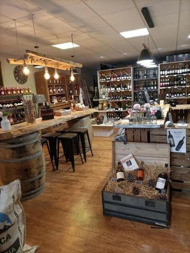 une pièce avec un magasin avec un comptoir et une pièce avec des tonneaux de vin dans l'établissement Gite de l'estampon, à Roquefort
