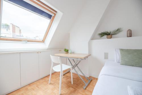 une petite chambre avec un lit et une table dans l'établissement CIA - Avenue de Villiers, à Paris