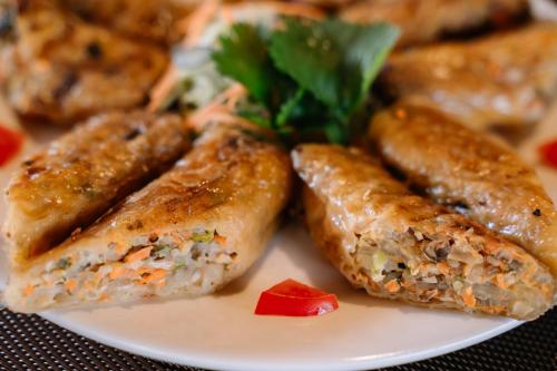 a plate of food with sausages and a garnishment at Anans Home Ha Giang - Tours & Motorbike Rental in Ha Giang