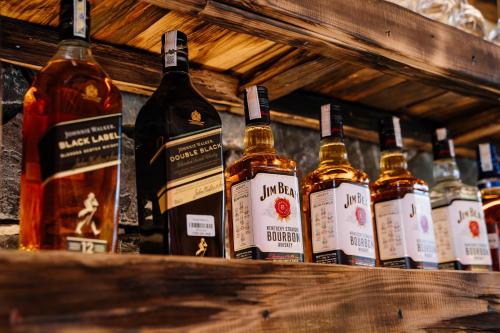 a row of bottles of whiskey on a shelf at Anans Home Ha Giang - Tours & Motorbike Rental in Ha Giang