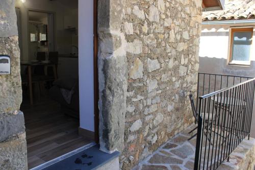 a stone wall next to a door to a house at L'ecureuil de luceram in Lucéram