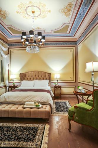 a bedroom with a king sized bed and a chandelier at 1905 Boutique Hotel in Xanthi