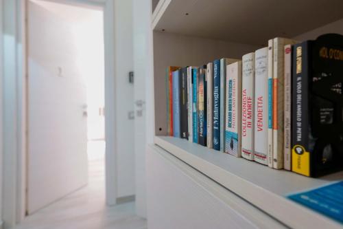 a row of books on a shelf in a room at Nùe Rooms in Cagliari