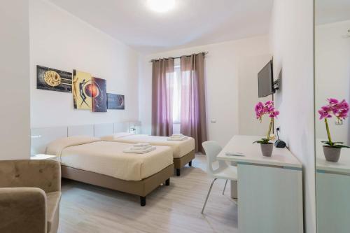 a hotel room with two beds and a table at Nùe Rooms in Cagliari