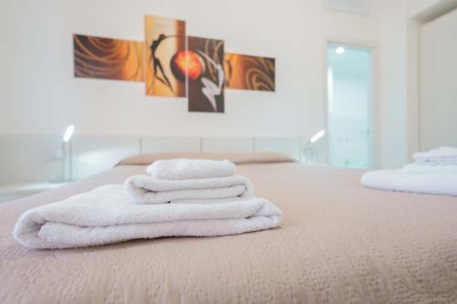 a group of towels sitting on top of a bed at Nùe Rooms in Cagliari