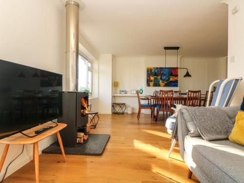 a living room with a couch and a fire place at Rock Pool House in Helston