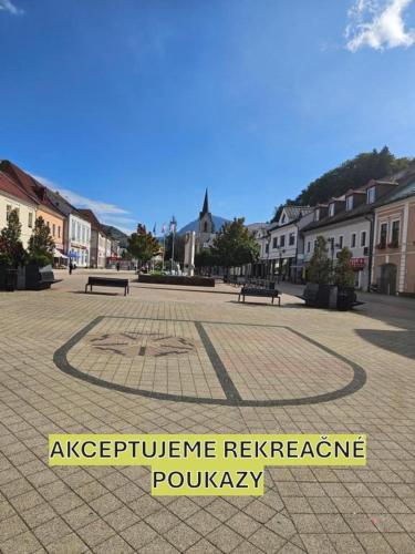a town square with benches in a square with a sign at COZY CENTRAL Apartment in Dolný Kubín