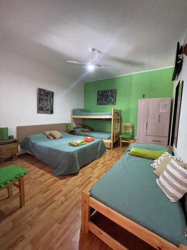 two beds in a room with green walls at Casa Mboyeré in Concepción del Uruguay