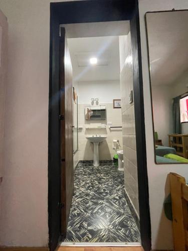 a hallway leading to a bathroom with a sink at Casa Mboyeré in Concepción del Uruguay